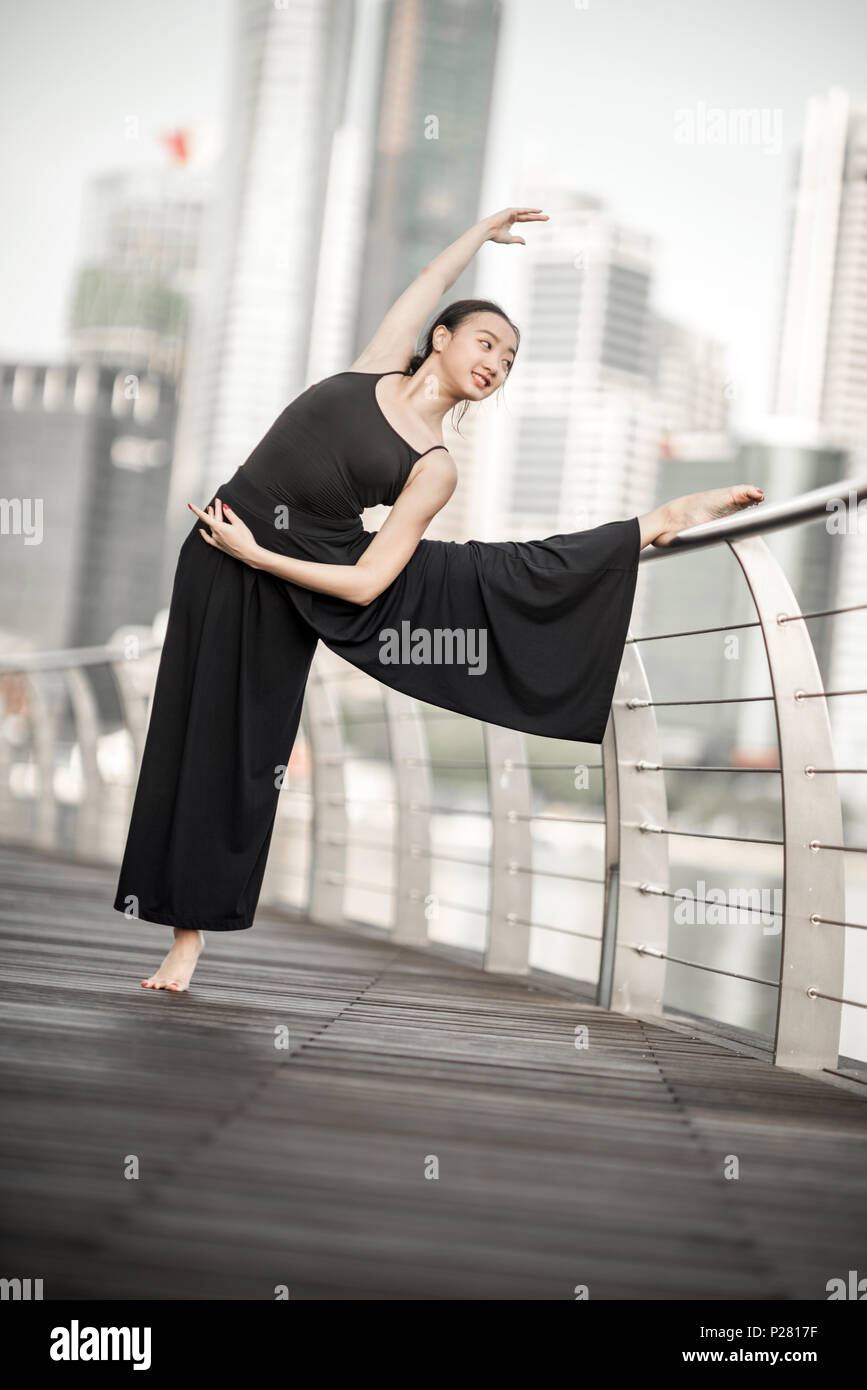 Schöne junge Mädchen tanzen in der Stadt, mit schwarzen, mit Hintergrund der Wolkenkratzer Stockfoto