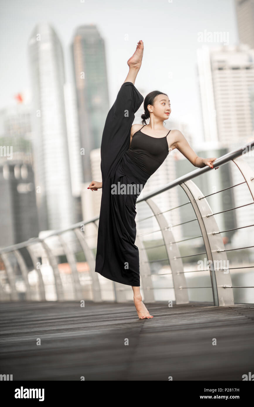 Schöne junge Mädchen tanzen in der Stadt, mit schwarzen, mit Hintergrund der Wolkenkratzer Stockfoto