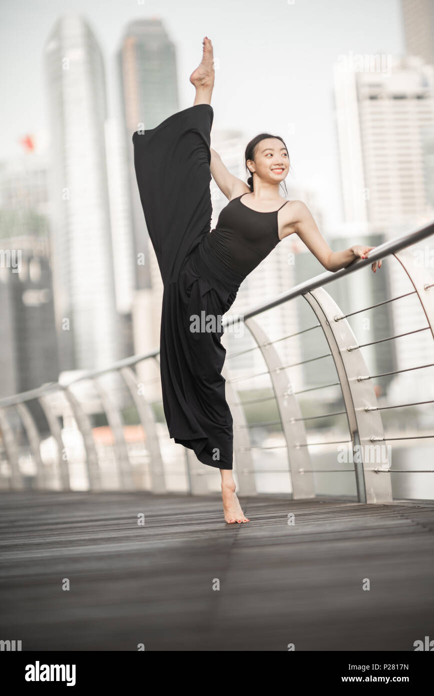 Schöne junge Mädchen tanzen auf einer Brücke Stockfoto