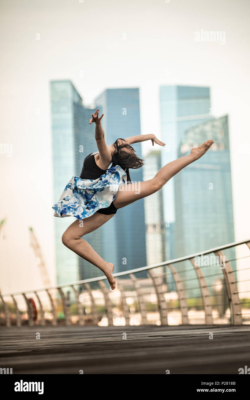Schöne junge Mädchen tanzen in der Stadt, mit Hintergrund der Wolkenkratzer Stockfoto