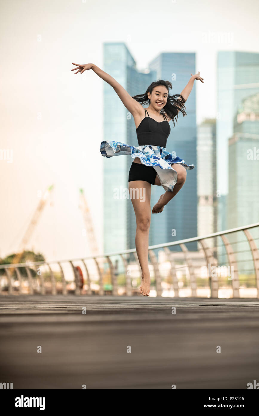 Schöne junge Mädchen tanzen in der Stadt, mit Hintergrund der Wolkenkratzer Stockfoto