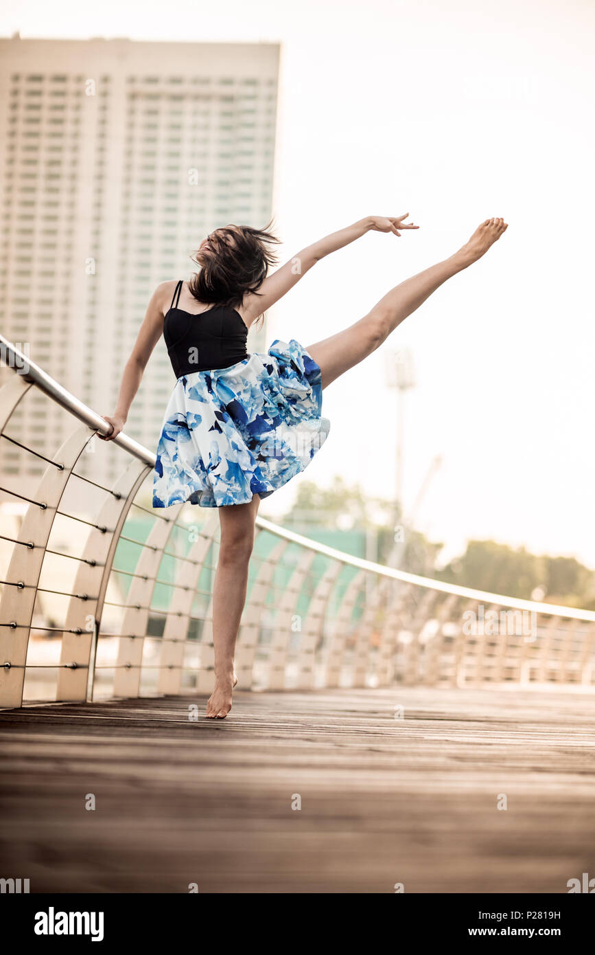 Schöne junge Mädchen tanzen in der Stadt, mit Hintergrund der Wolkenkratzer Stockfoto