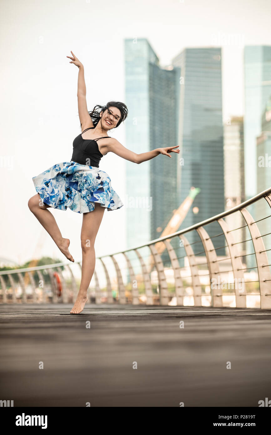 Schöne junge Mädchen tanzen in der Stadt, mit Hintergrund der Wolkenkratzer Stockfoto