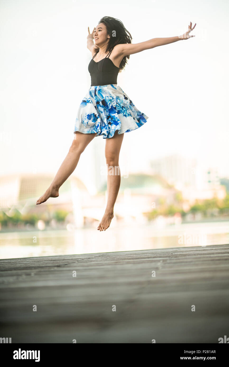 Schöne junge Mädchen tanzen in der Stadt, mit Hintergrund der Wolkenkratzer Stockfoto