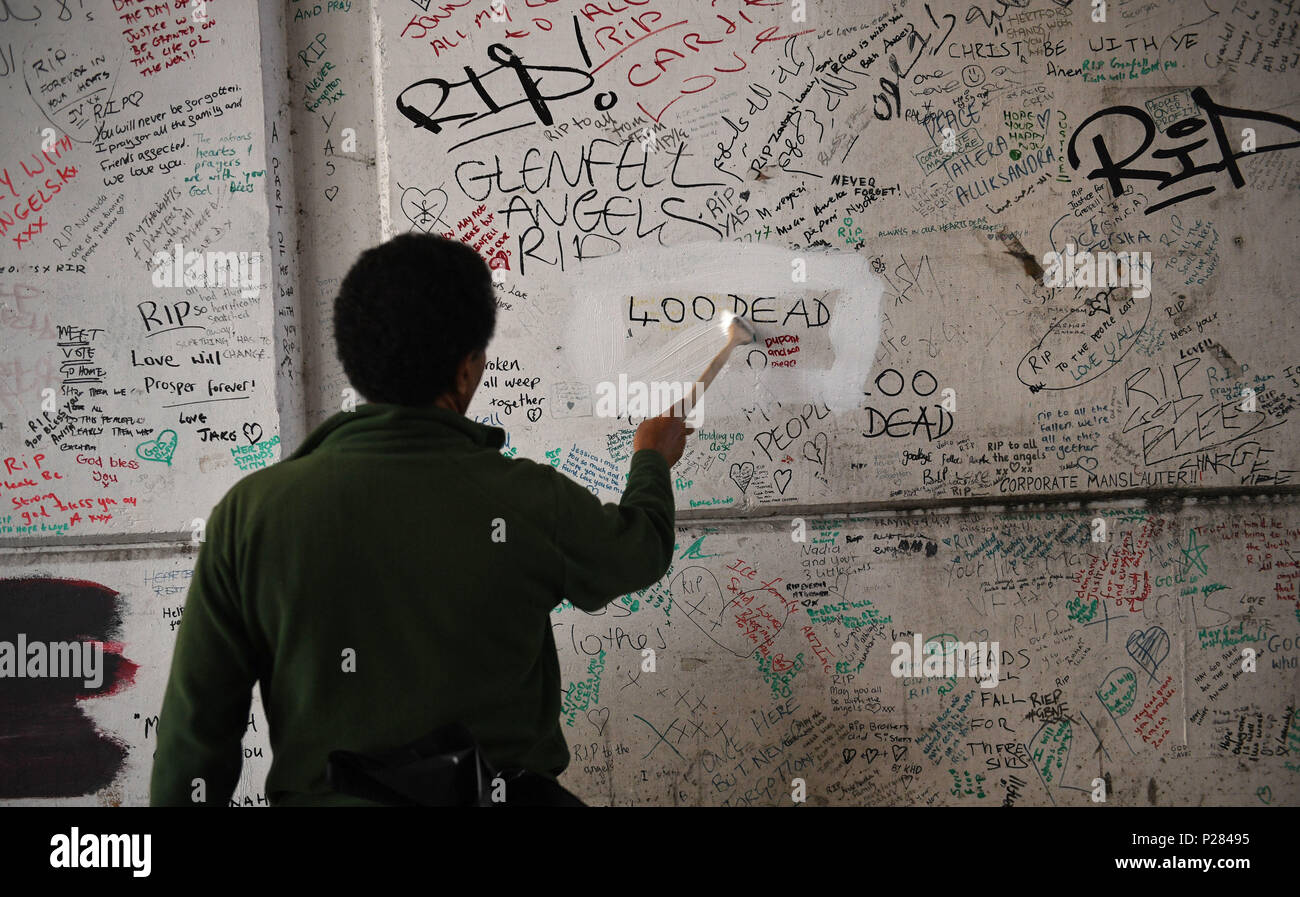 Hat ein Arbeitnehmer erklärt worden, über einen Teil der Graffiti auf der Grenfell Mauer der Erinnerung, die lautet: "400 Tote" zu malen. Stockfoto