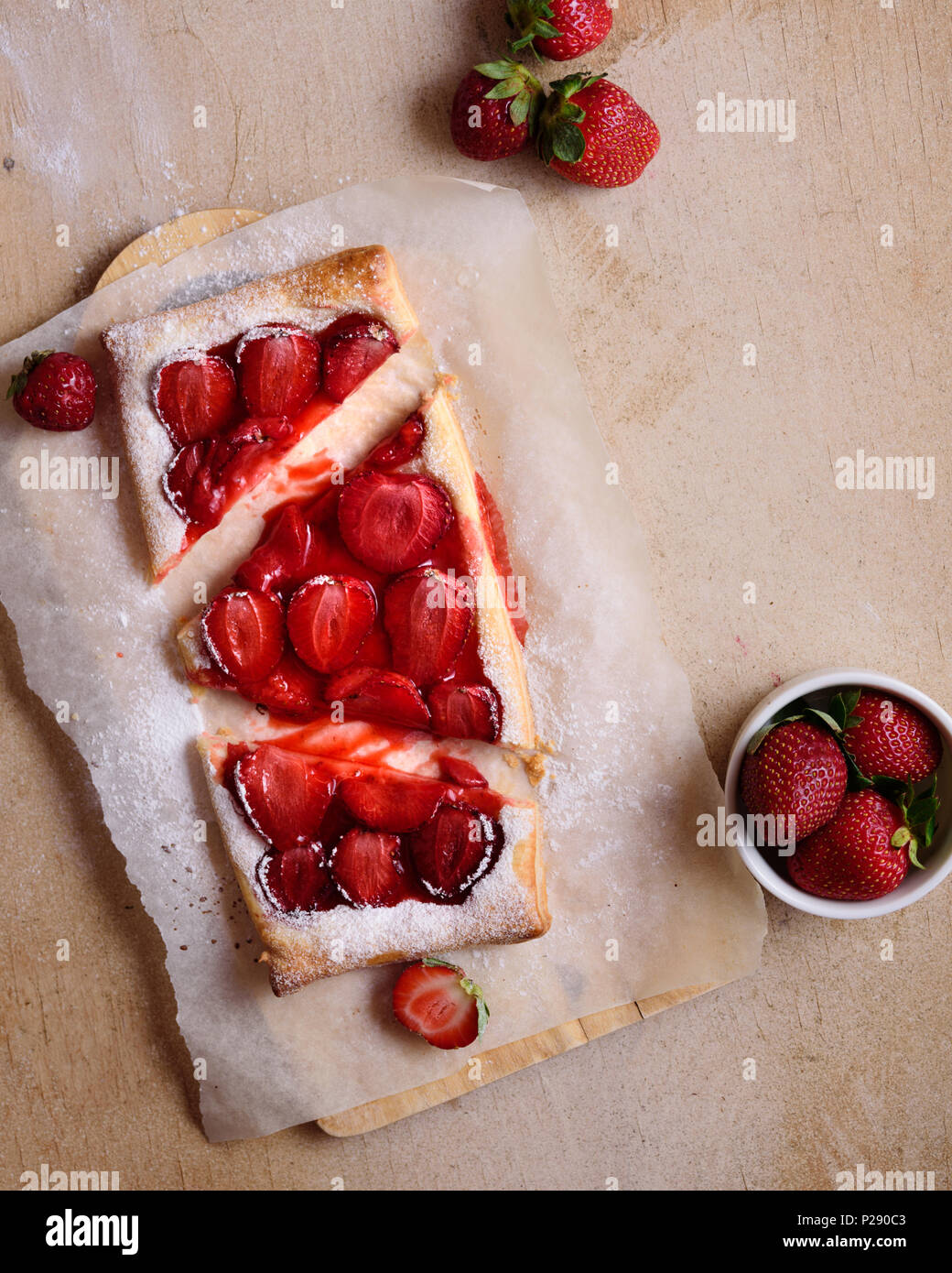 Erdbeertorte mit Puderzucker auf Schneidebrett Stockfoto
