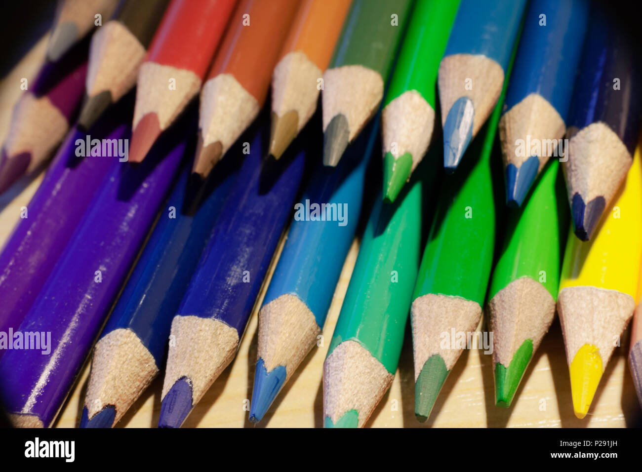 Ein Satz farbiger Bleistifte über eine Tabelle. Makro Nahaufnahme. Konzept: Zurück in die Schule. Stockfoto