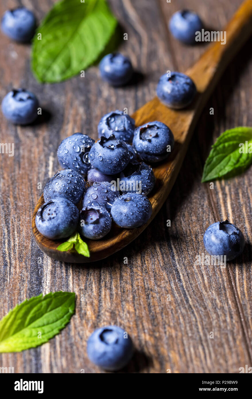 Frische Blaubeeren und minzeblatt auf hölzernen Löffel. Nützlich für Obst Hintergrund. Stockfoto