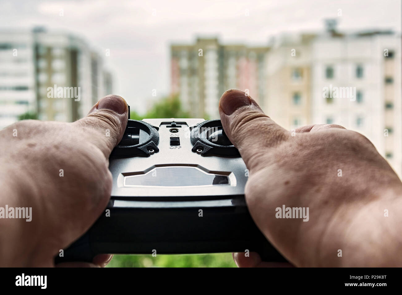 Fernbedienung drone in den Händen auf einem unscharfen Hintergrund von mehrgeschossigen Gebäuden Stockfoto