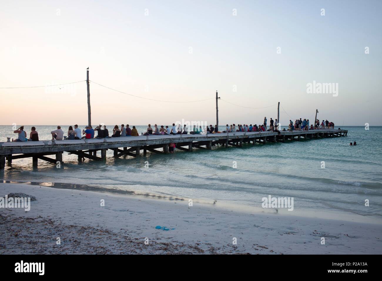 Mexiko, Quintana Roo, Lázaro Cárdenas, Isla Holbox, Touristen warten auf den Sonnenuntergang auf dem Deich Stockfoto