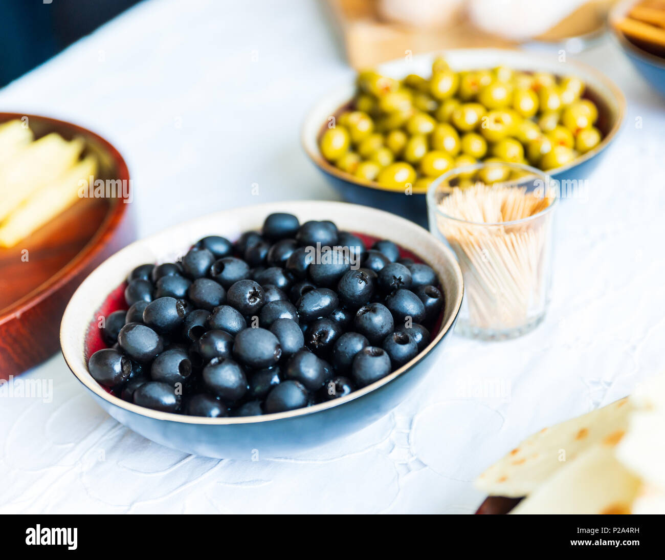 Schwarze und Grüne Oliven in Schalen auf weißen Tisch Stockfoto
