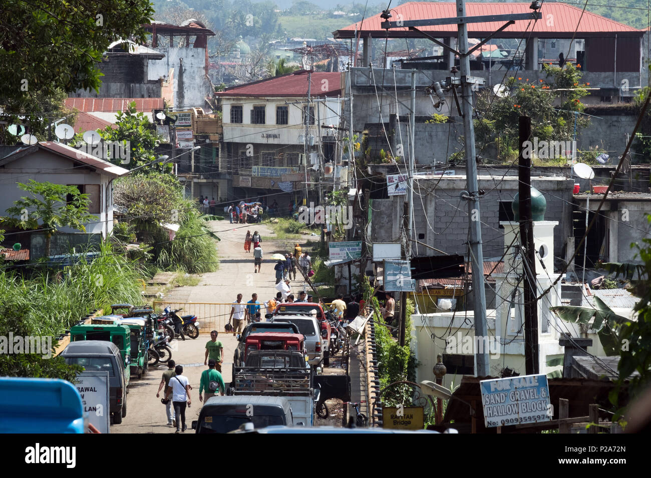 Kreuzung aus der erhaltenen Teile der Marawi - Stadt in die zerstörte Innenstadt (Ground Zero) der Stadt Marawi. Die Bewohner sind nur erlaubt, ihre Habseligkeiten zu Fuß zu bringen. Insel Mindanao, Philippinen - Übergang vom erhaltenen Stadtteilen in die zerstörte Innenstadt (Ground Zero) der Stadt Marawi. Feuerstelle your Lehrredaktion dürfen nur zu Fuß herüber bringen. Insel Mindanao, Philippinen Stockfoto