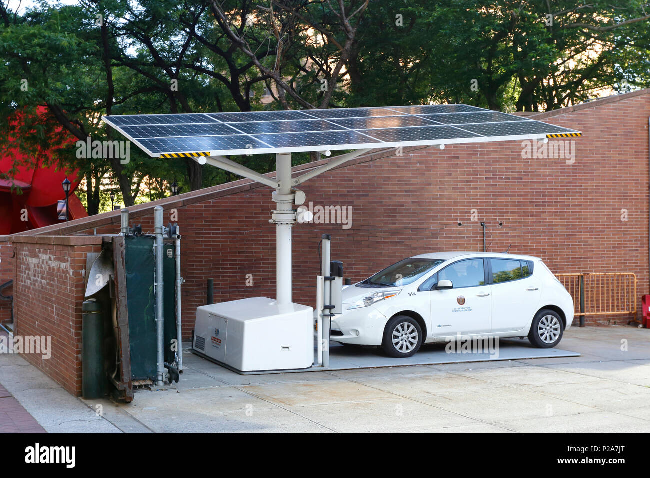 Eine solarbetriebene EV Arc EV-Ladestation, die mit einem Elektroauto von Nissan Leaf aufgeladen wird, das der Stadt New York gehört Stockfoto