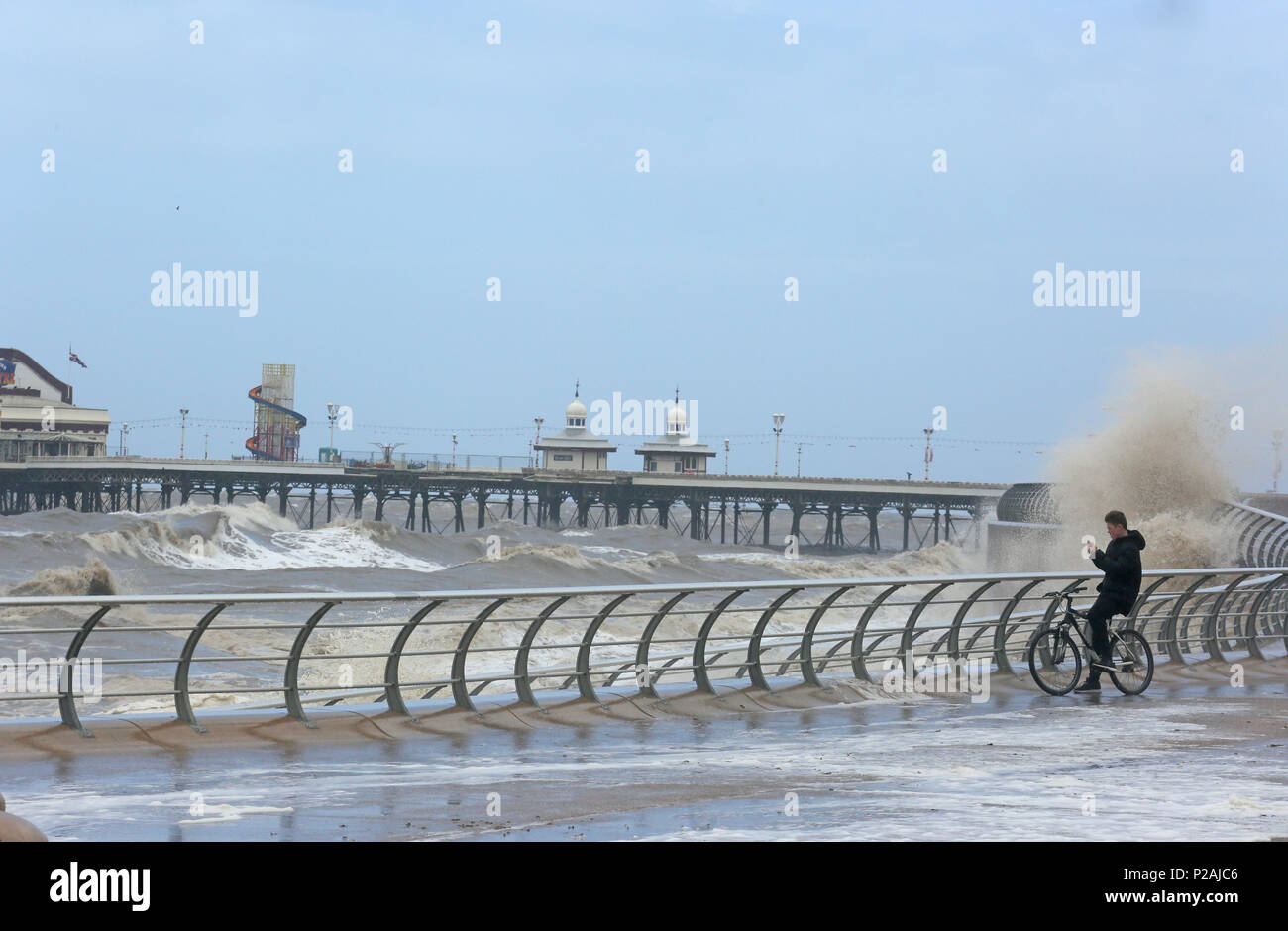 Blackpool, Großbritannien. 14 Jun, 2018. UK Wetter: Ein junger Mann auf einem Zyklus beobachten Sturm Tyrannen Ankunft holen sich brechenden Wellen bei Flut in Blackpool, 14 Juni, 2018 (C) Barbara Cook/Alamy leben Nachrichten Stockfoto