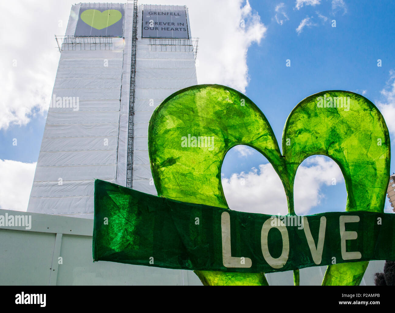 Ein riesiges Banner mit dem Wort "Liebe" an der Basis der Grenfell Turm links ist der Jahrestag des Brandes, London, England, Großbritannien, 14. Juni 2018 Stockfoto