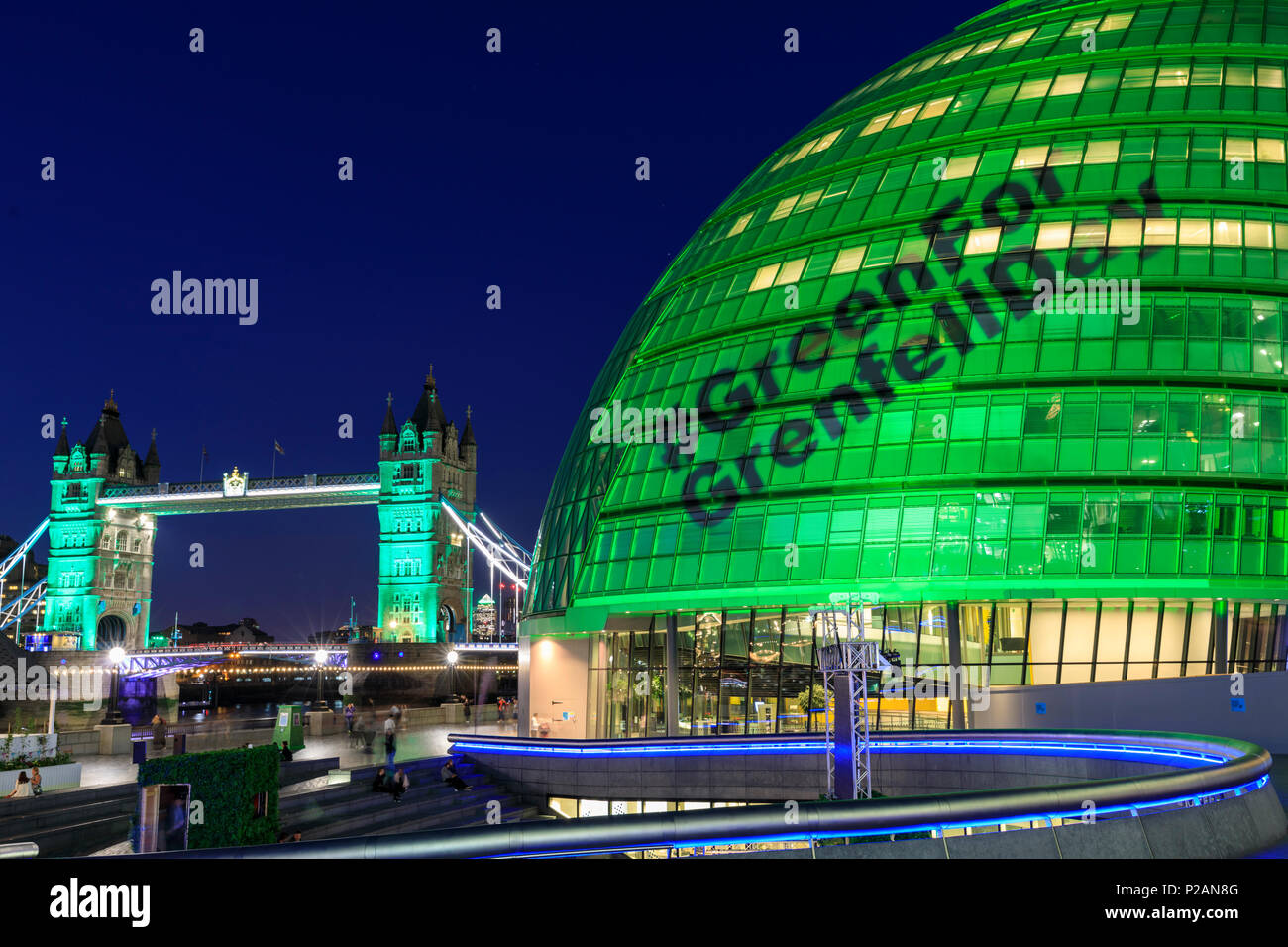 City Hall, London, UK, 14. Juni 2018. Rathaus und die Tower Bridge sind in grün beleuchtet, und das Hashtag #GreenForGrenfellDay auf Rathaus zur Erinnerung an die Grenfell Turm Feuer und diejenigen, die ihr Leben in den tragischen Ereignissen, die vor einem Jahr passiert ist verloren projiziert wird. Credit: Imageplotter Nachrichten und Sport/Alamy leben Nachrichten Stockfoto