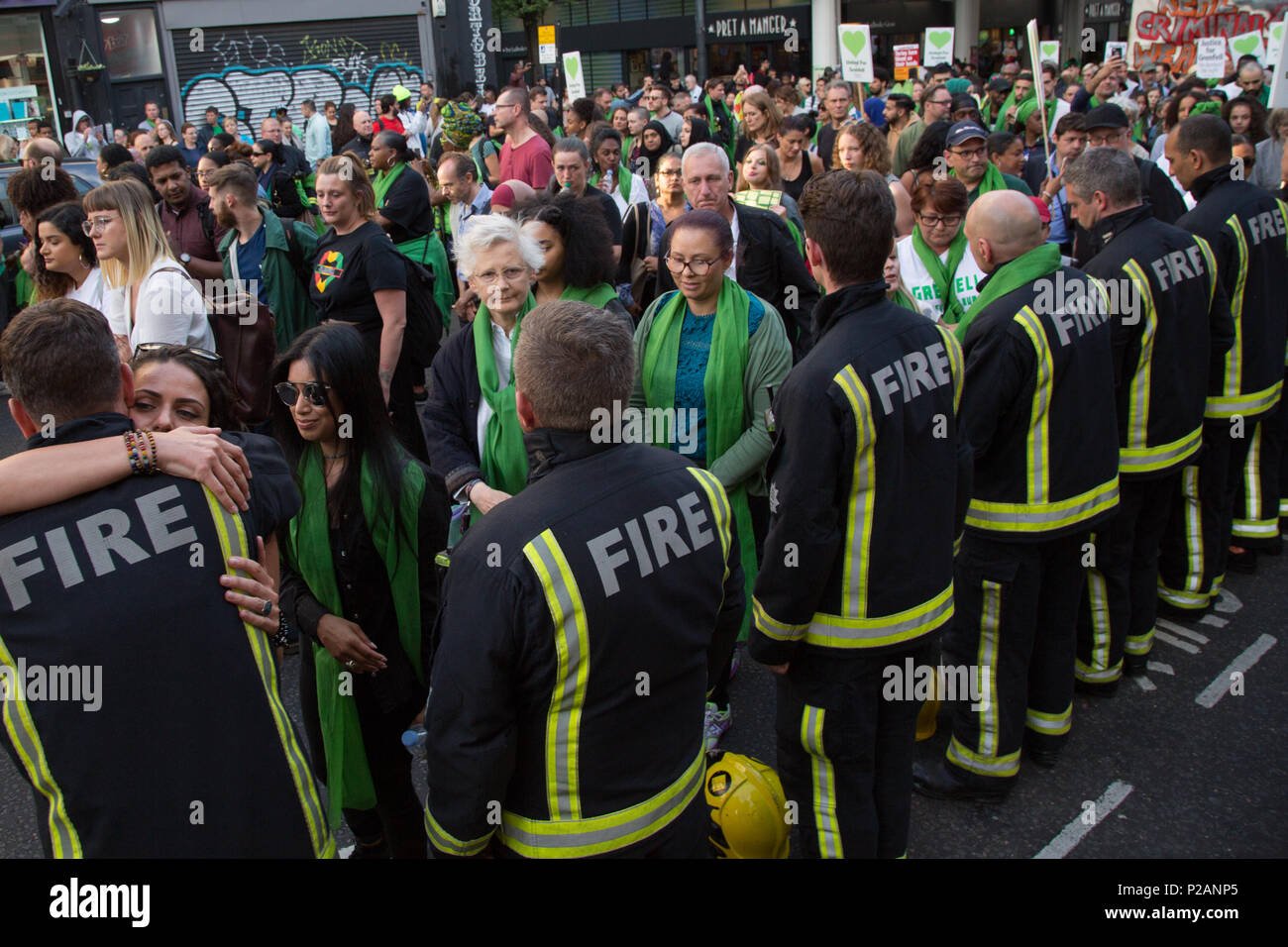 London UK 14. Juni 2018 Menschen aufhören zu umarmen Feuerwehrmänner bei einem schweigemarsch St Mark's Park (Kensington Memorial Park) am Jahrestag der Grenfell Turm Feuer. Credit: Thabo Jaiyesimi/Alamy leben Nachrichten Stockfoto