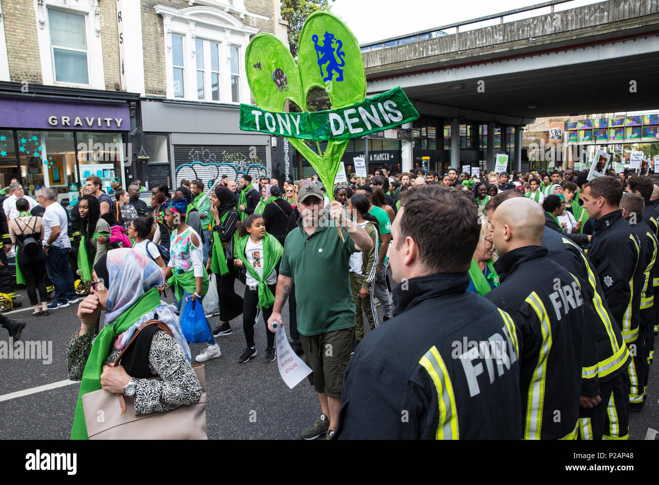 London, Großbritannien. 14 Juni, 2018. Mitglieder der Grenfell Gemeinschaft vielen Feuerwehrmänner vom Londoner Feuerwehr bilden ein Spalier für die Grenfell Schweigemarsch durch West Kensington am ersten Jahrestag der Grenfell Turm Feuer. 72 Menschen in der Grenfell Turm Feuer und über 70 Tote wurden verletzt. Credit: Mark Kerrison/Alamy leben Nachrichten Stockfoto