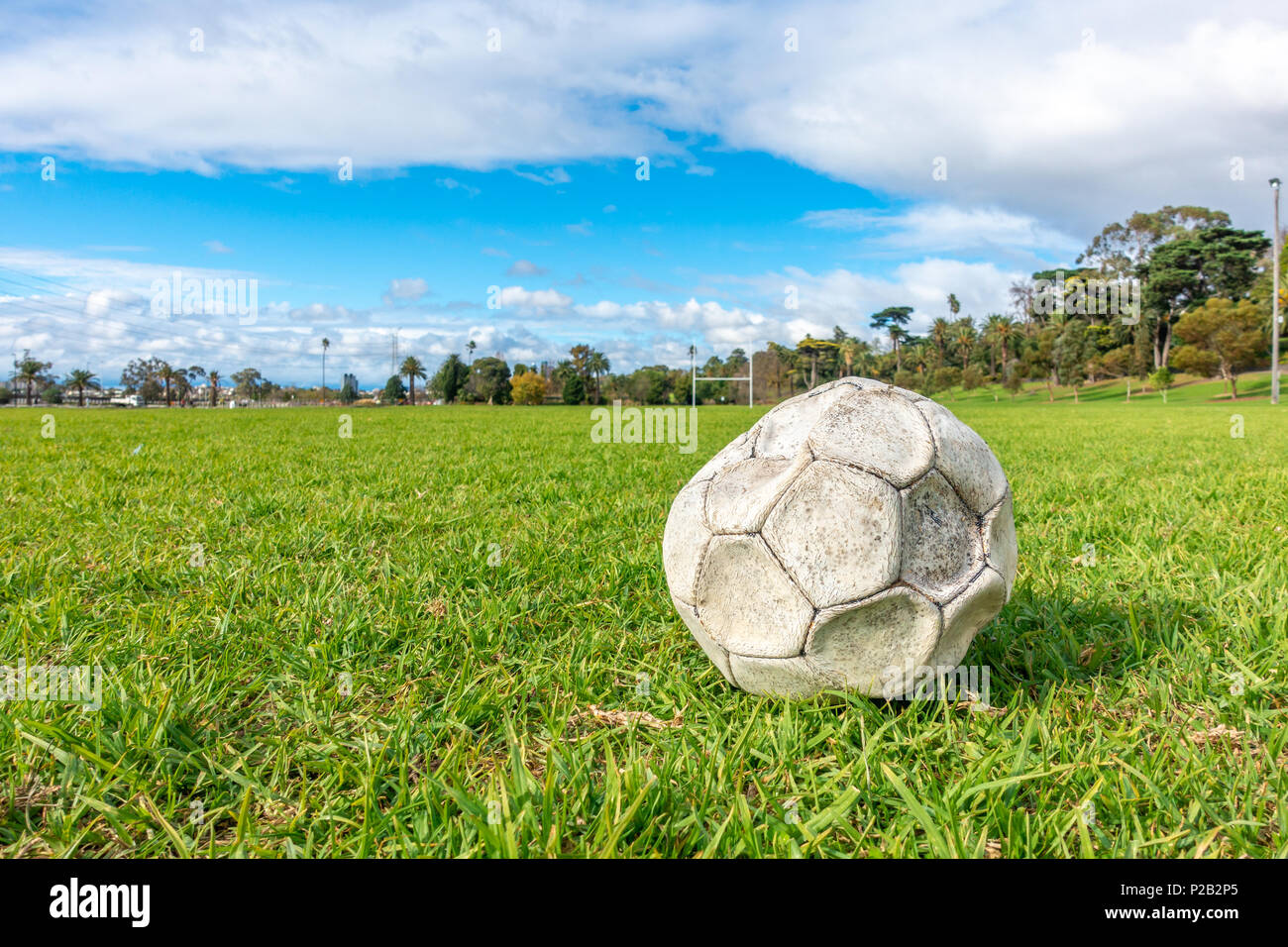 Alte leck Fußball/Fußball auf der grünen Wiese aufgegeben. Konzept der Traurigkeit, Hoffnungslosigkeit und Einsamkeit. Stockfoto