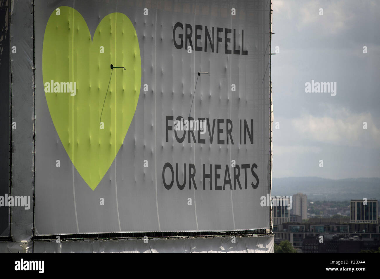 Eine Fahne mit einem grünen Herz ist rund um die Grenfell Turm ein Jahr seit der Flamme, die 72 Menschenleben gefordert. Stockfoto