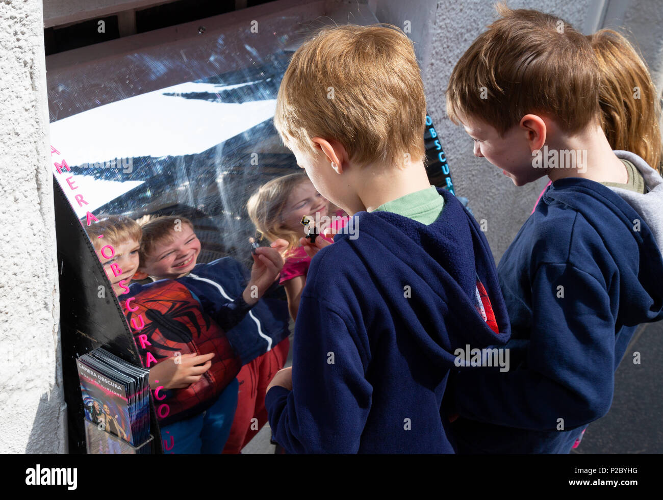 Glückliche Kinder Spaß mit der Reflexion in einem Spiegel Verzerrung, Edinburgh. Schottland Großbritannien Stockfoto