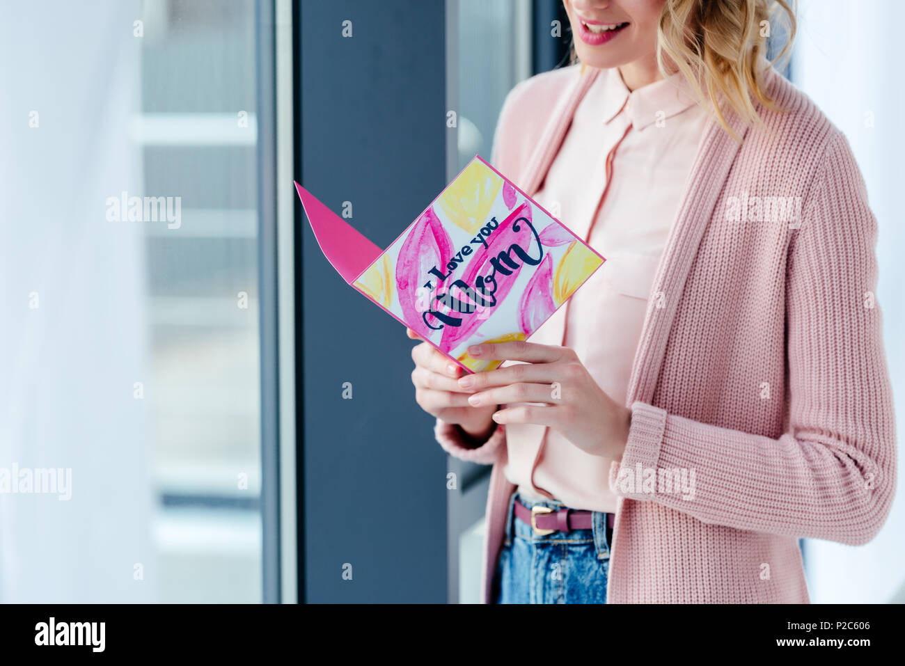 Teilweise mit Blick auf die lächelnde Frau lesen Ich liebe dich Mama Postkarte in den Händen, Muttertag urlaub Konzept Stockfoto