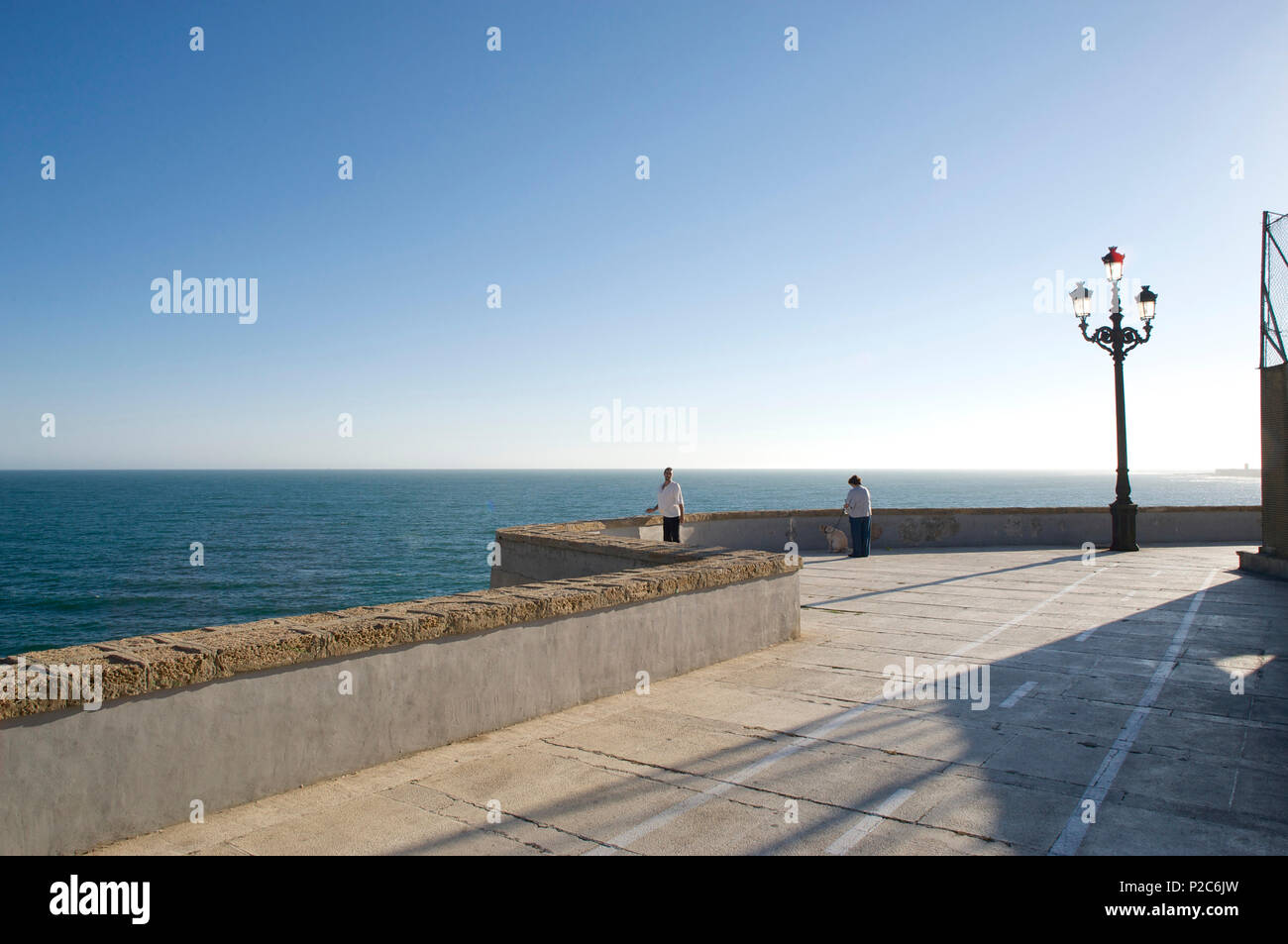 Promenade am Meer mit Wand- und elektrisches Licht im alten Stil, Blick über das Meer mit zwei einsame Menschen, Cadiz, Andalusien, Spa Stockfoto