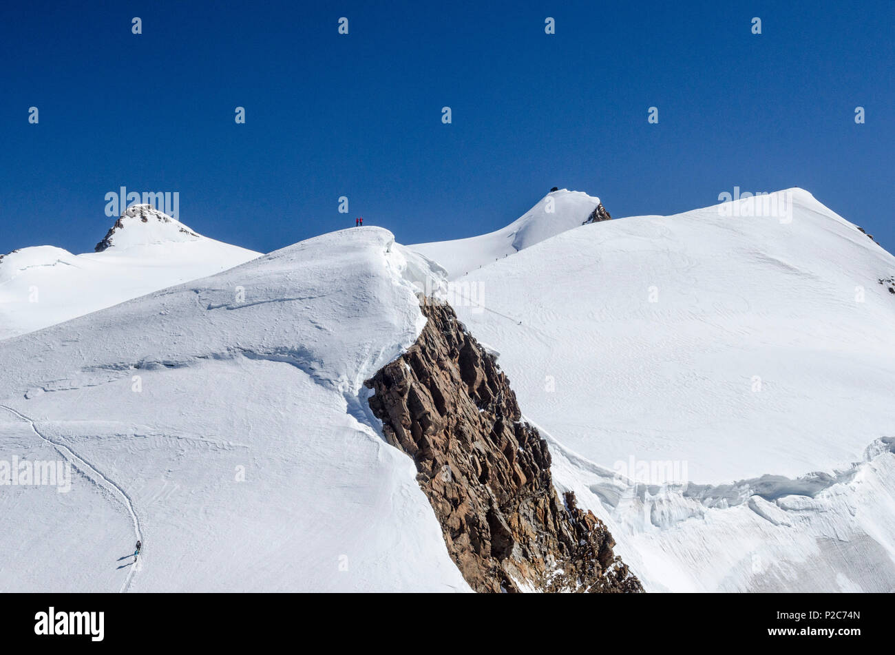 Zwei Bergsteiger auf dem Gipfel des Ludwigshoehe, hinter Ihnen vier Personen klettern Parrotspitze, im Hintergrund t Stockfoto