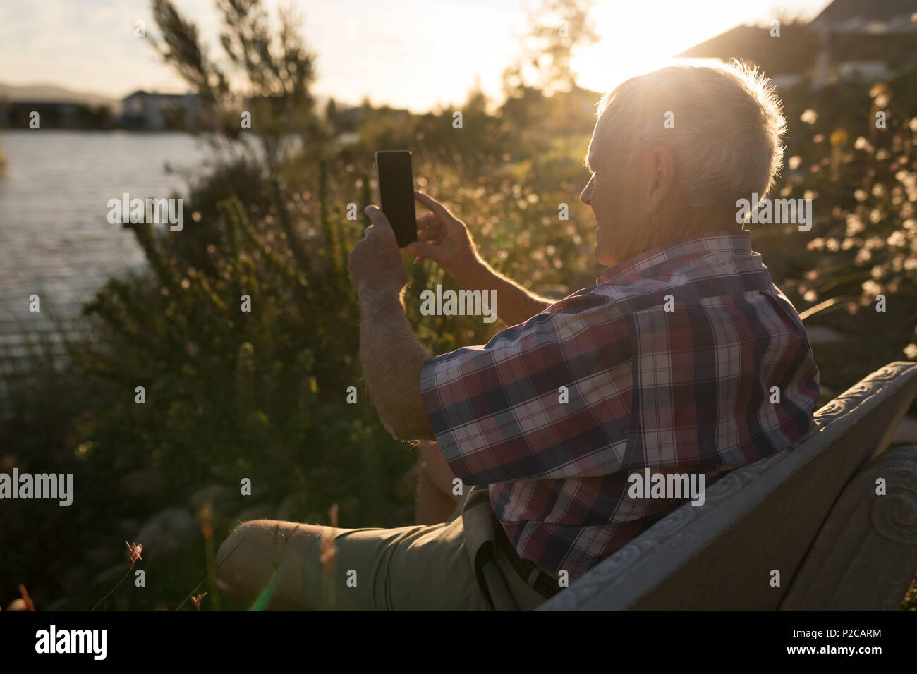 Ältere Menschen unter Foto mit Handy am Flußufer Stockfoto
