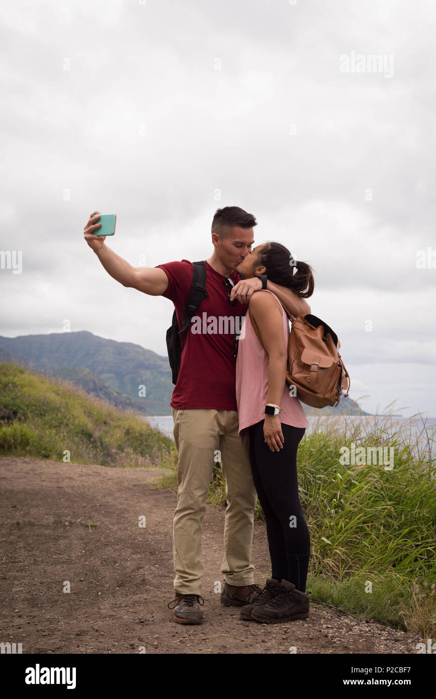 Paar einander küssen während der Einnahme von selfie mit Handy Stockfoto