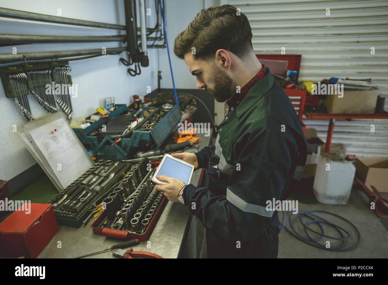Mechaniker mit digitalen Tablet an Werkbank Stockfoto