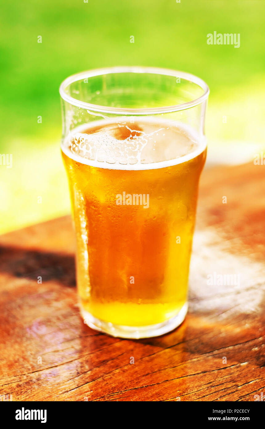 Glas 500 ml Bier ohne Schaum auf einem holztisch an einem sonnigen Tag. Stockfoto