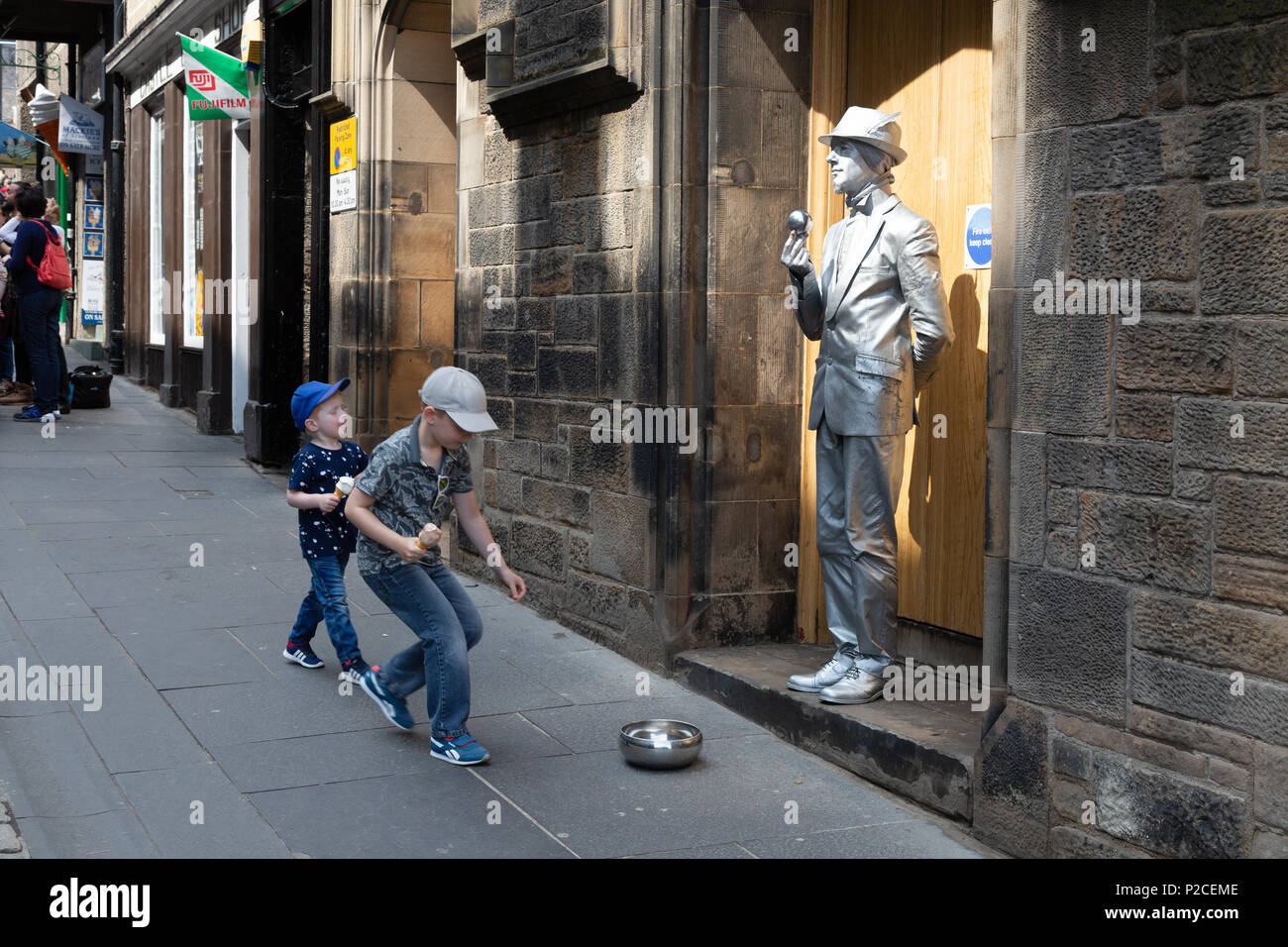 Kinder Geld zu einem Street Performer durchführen, die Royal Mile, die Altstadt von Edinburgh, Schottland Großbritannien Stockfoto