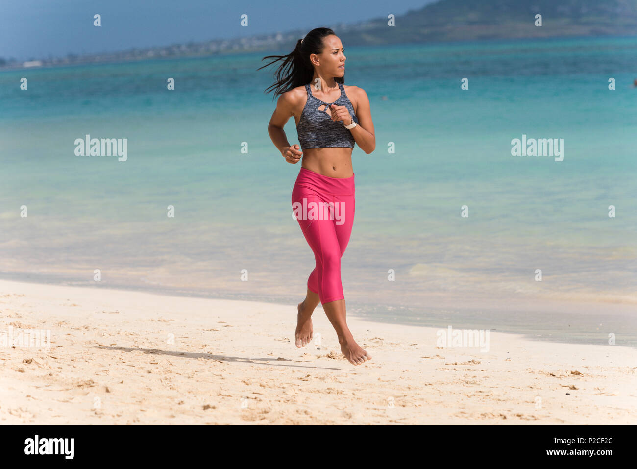 Frau Jogging am Strand Stockfoto