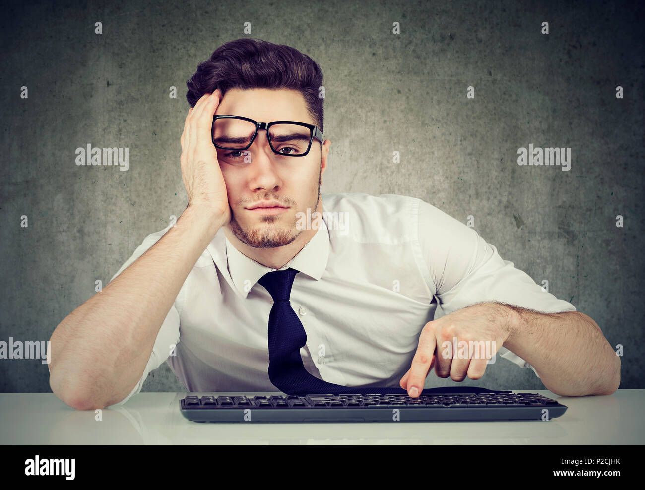Sleepy gelangweilt Mann Mitarbeiter am Schreibtisch sitzen hat keine Motivation zur Arbeit Stockfoto
