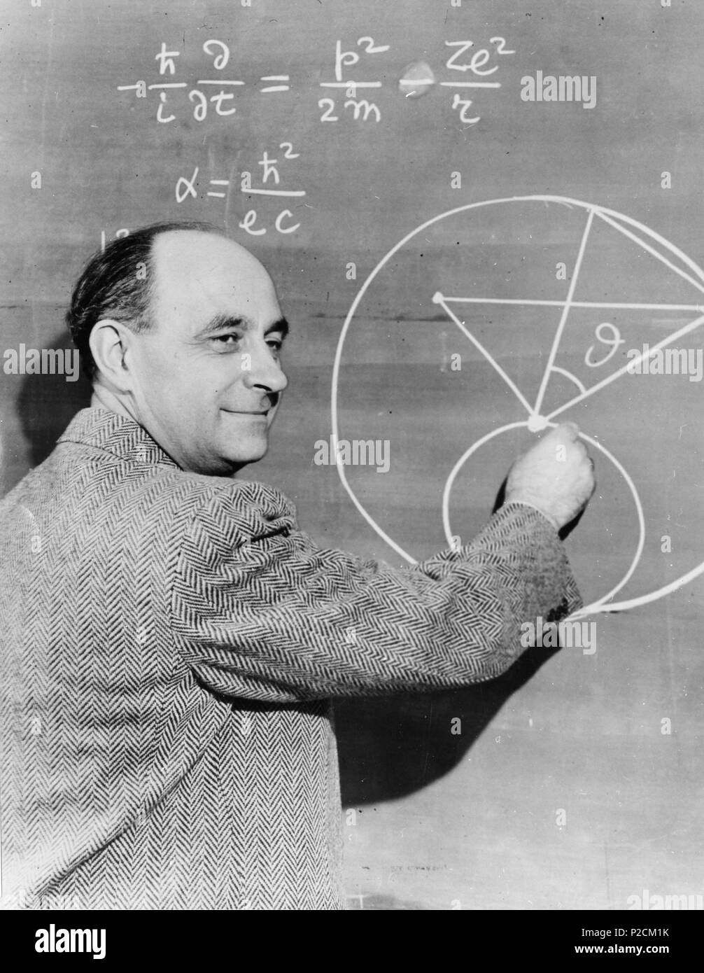 . Englisch: Enrico Fermi an der Tafel. Interessant ist, dass die Tafel enthält einen Fehler: Die Gleichung für die feinstrukturkonstante sollte lesen? ? = e2? ? C{displaystyle alpha={frac{e^{2}}{hbar{}c}}}. Datum unbekannt. Smithsonian Institution 18 Enrico Fermi an der Tafel Stockfoto