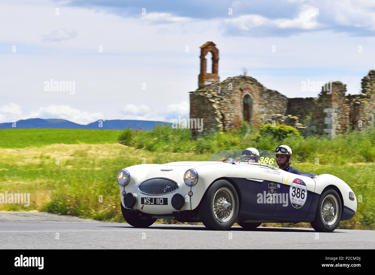 Austin Healey 100S, 1955, Oldtimer auf einer Straße in der Nähe von Ruinen durch die toskanischen Tal, Mille Miglia, 1000 Miglia, 2014, San Quirico Stockfoto