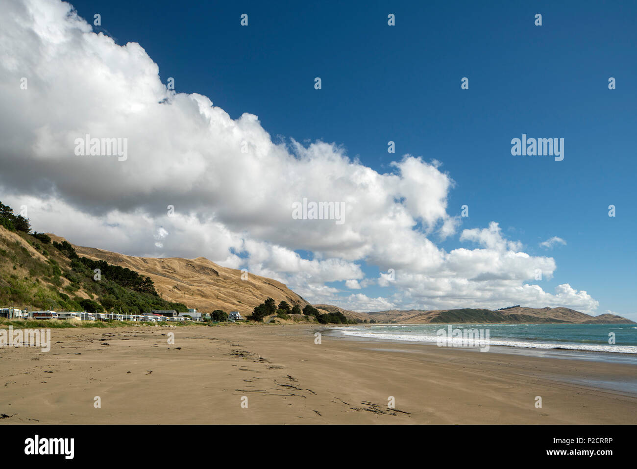 Strand und Meer und Hügel neben Strand Haus mit Wolken. Historische Pourerere Bach/Beach House, Hawke's Bay, Neuseeland mit neuen hinaus von Arch Stockfoto