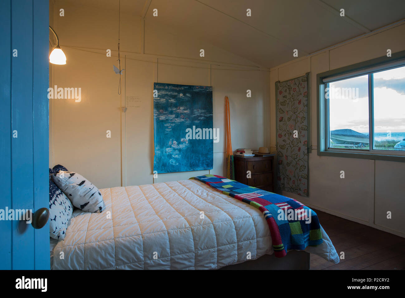 Schlafzimmer des alten Bach/Beach House in NZ mit Blick aus dem Fenster. Historische Pourerere Bach/Beach House, Hawke's Bay, Neuseeland mit neuen hinaus durch Stockfoto