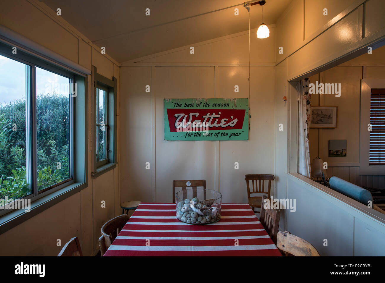 Essbereich mit roten und weißen Tischdecke von Strand mit Watties Werbung zu unterzeichnen. Historische Pourerere Bach/Beach House, Hawke's Bay, Neuseeland mit Stockfoto