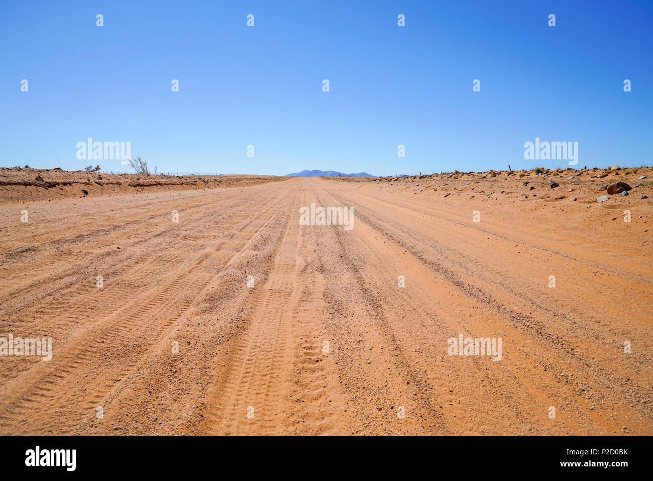 Reifenspuren in staubigen roten Sand road Stretching weit voraus durch Namibia Landschaft. Stockfoto