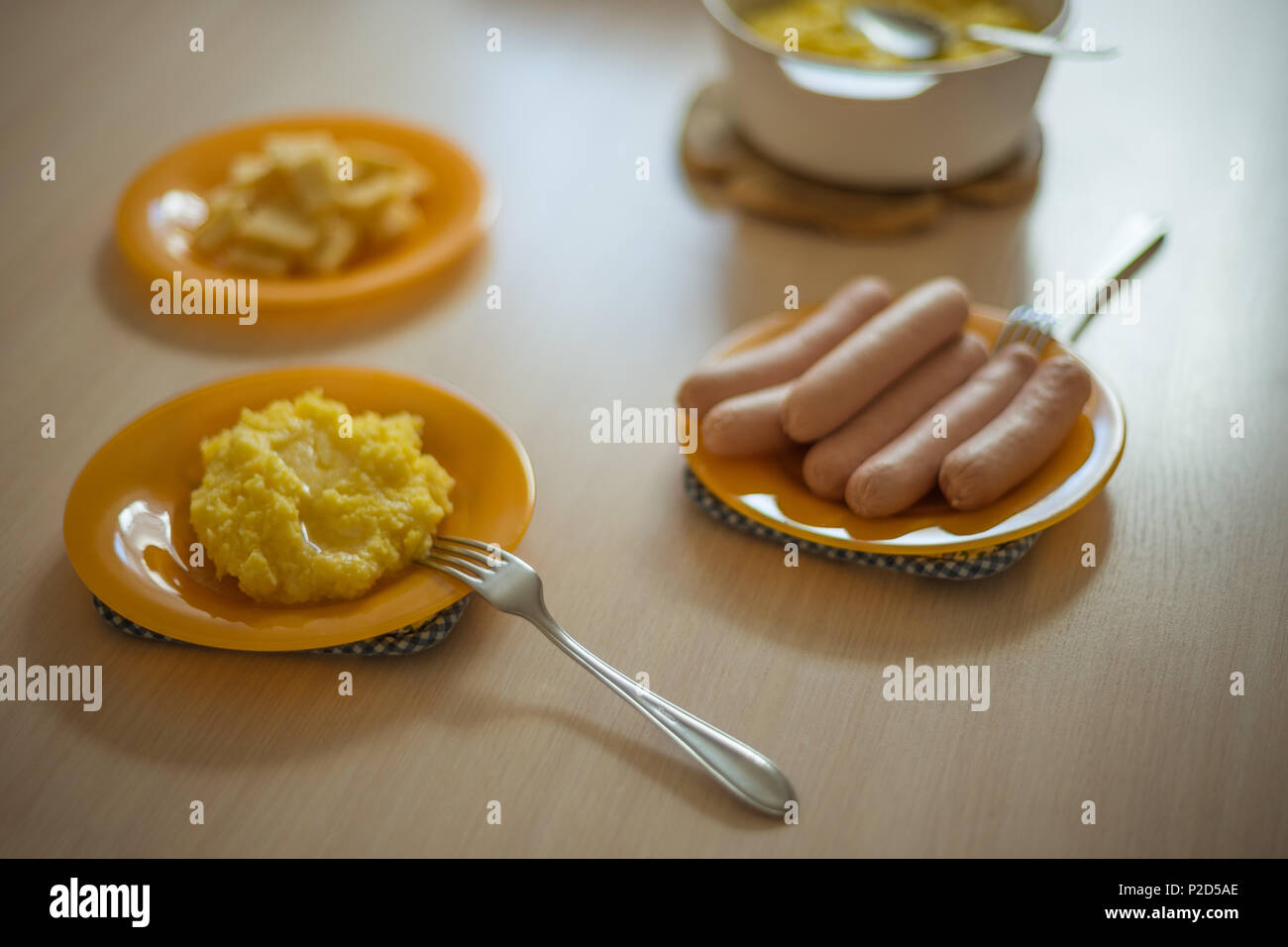 Weizen Haferbrei, Wurst und Käse in orange Teller auf dem Küchentisch Stockfoto