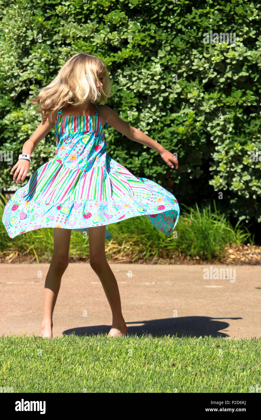 Junge Mädchen glücklich twirling in ihr Sommer Kleid Stockfoto