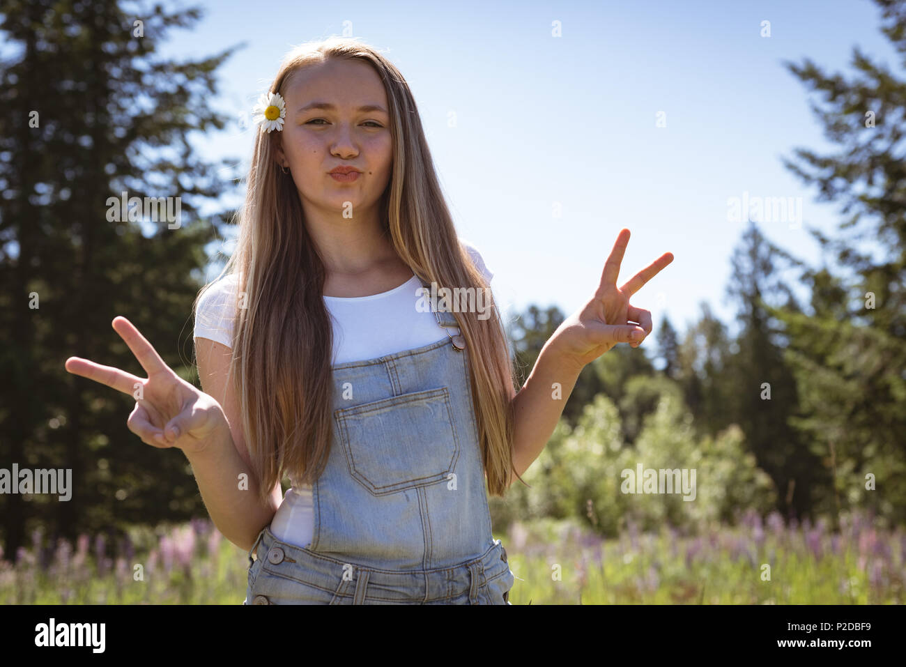 Mädchen zeigen v Zeichen im Feld an einem sonnigen Tag Stockfoto