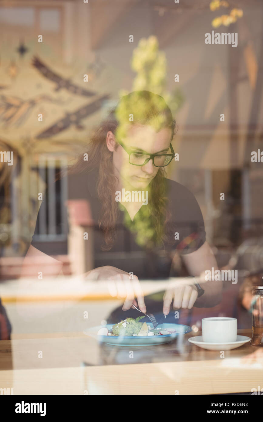 Frau mit Frühstück und Kaffee am Tisch Stockfoto