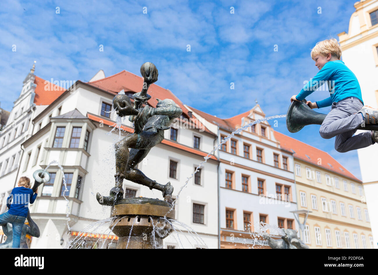 Junge sitzt auf dem Brunnen vor dem Rathaus, Torgau, Sachsen, Deutschland, Europa Stockfoto