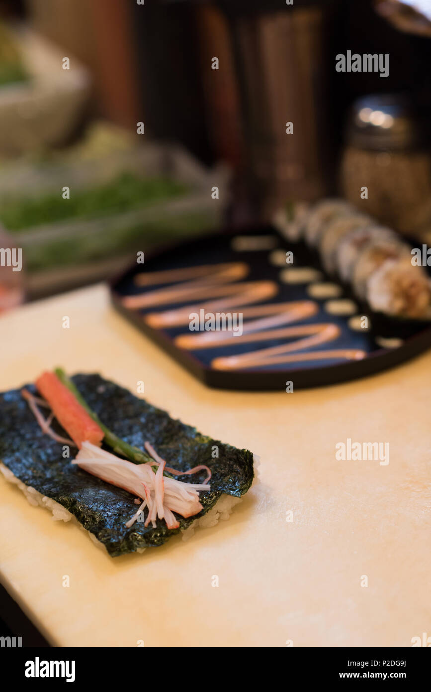 Abgerollt Sushi gehalten auf einem Tisch Stockfoto