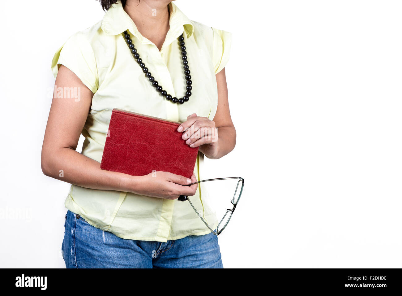 In der Nähe der jungen Frau legere Kleidung und Halskette holding Buch und Gläser auf weißem Hintergrund. Stockfoto