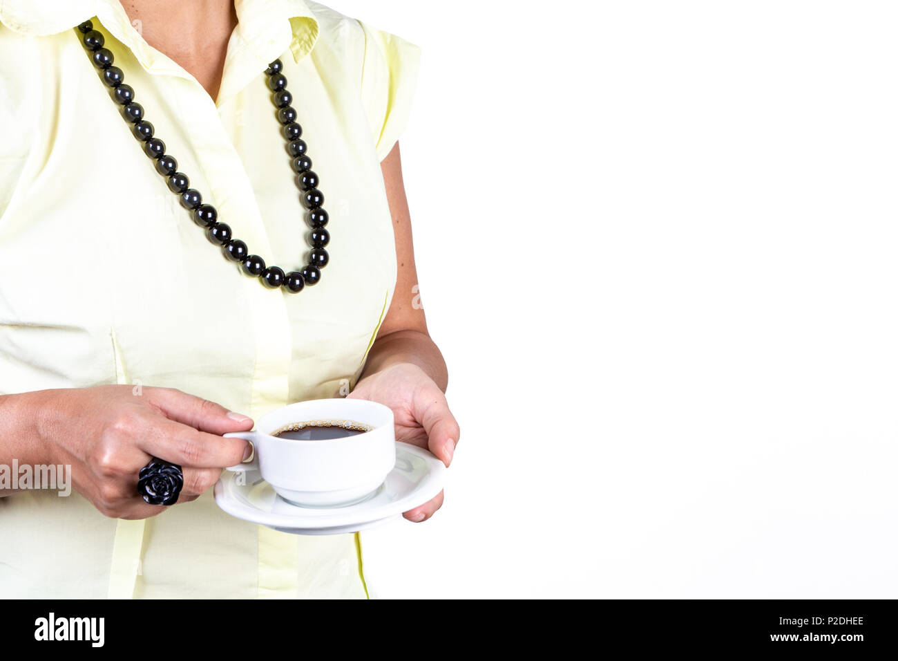 In der Nähe der jungen Frau legere Kleidung und Halskette Holding eine Tasse Kaffee schwarz auf weißem Hintergrund. Stockfoto