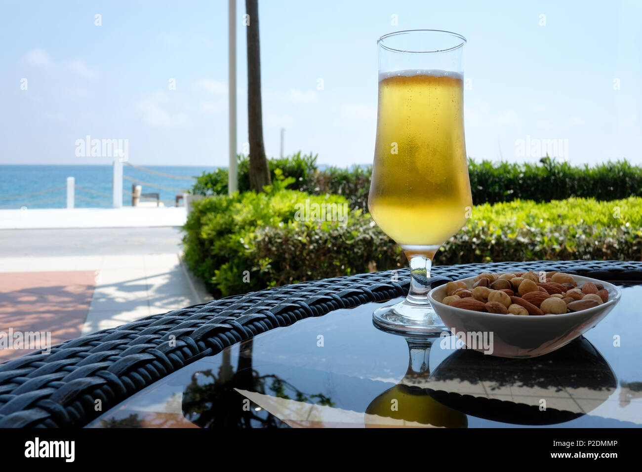 Tasse Bier mit Muttern Snacks auf Glas Tisch Stockfoto